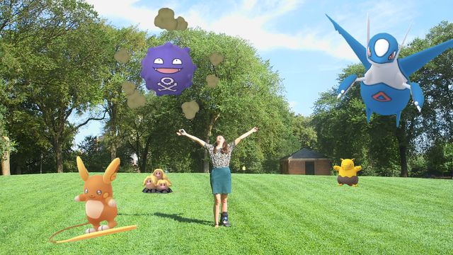 Simone is standing in the center of a grassy field under a bright blue sky. She flings out her arms and shouts to the high heavens. Around her, four Pokemon are chilling: a Koffing and a Latios float above her, there is an Alolan Dugtrio rocking out to he